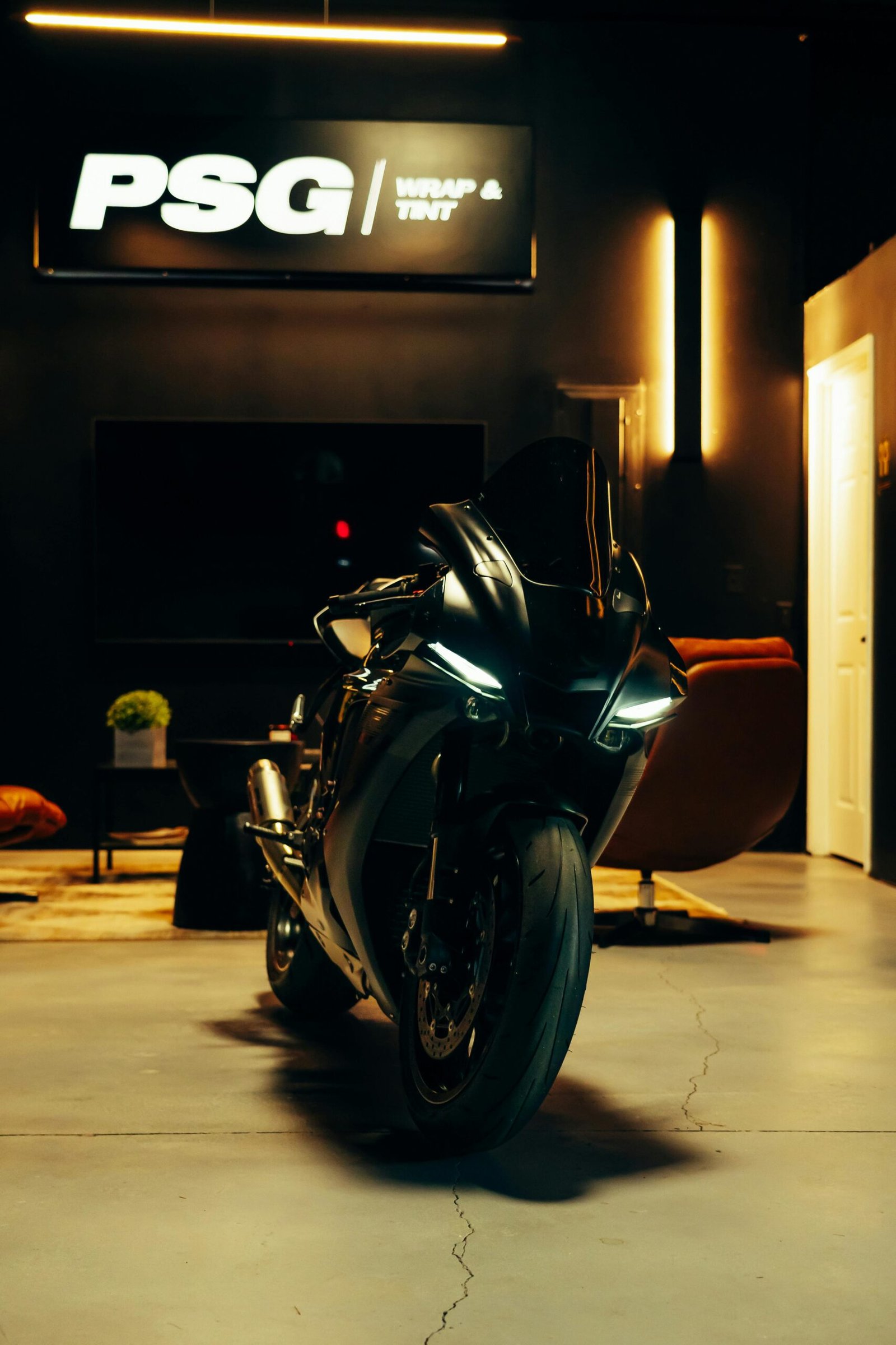 A glossy black motorcycle parked indoors, exuding a modern and stylish mood.